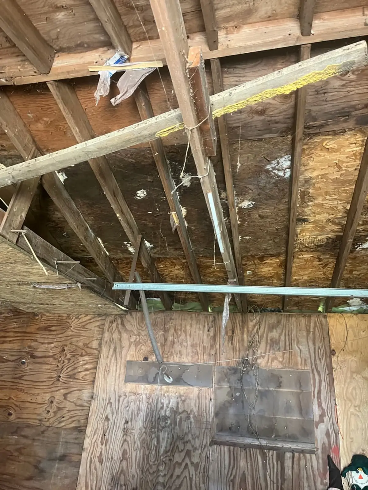 Selling a storm-damaged house in Medford: garage roof seen from inside with water-stained sheathing
