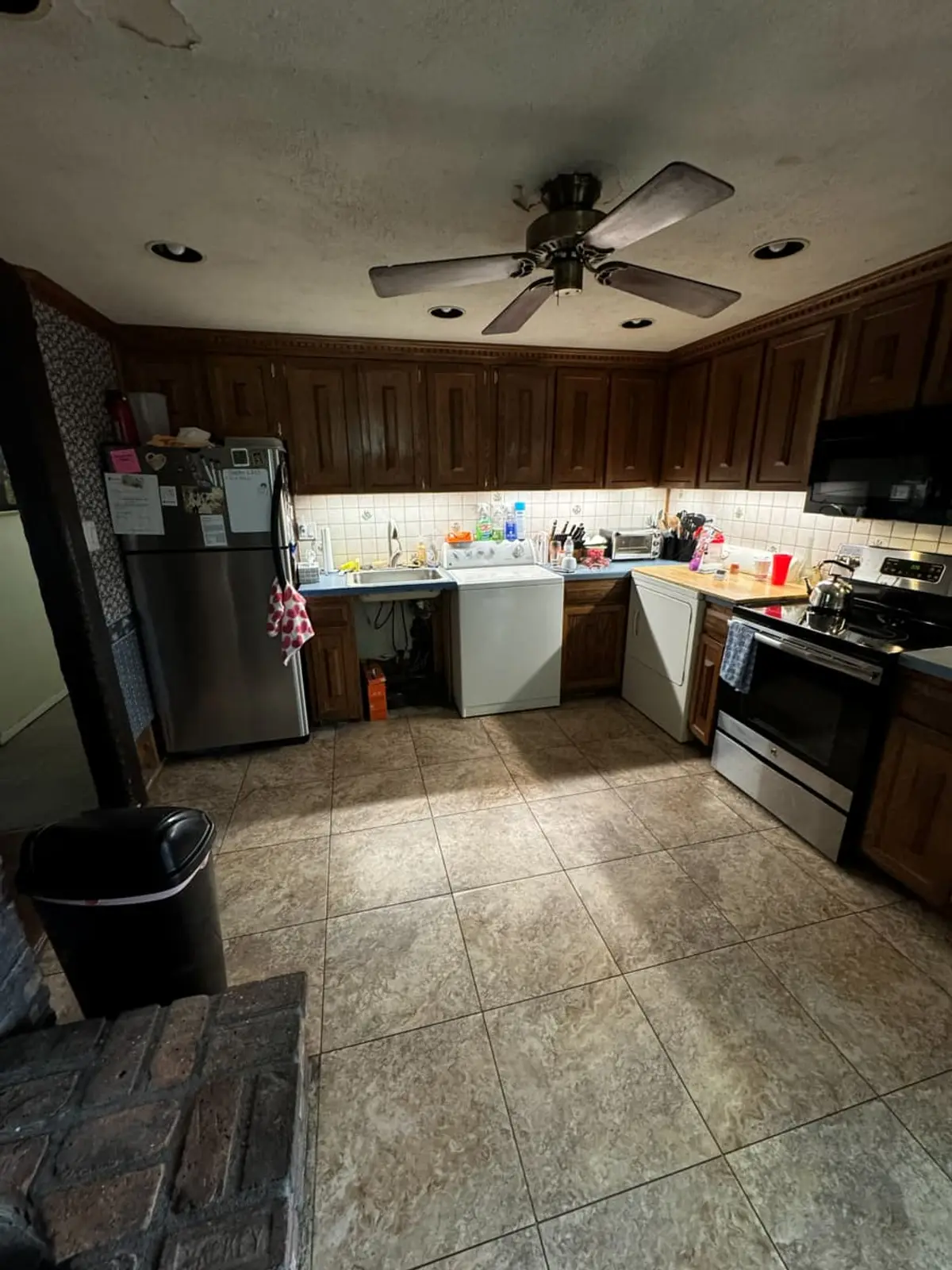 Selling a house with tenants in it in Medford: open kitchen with dark wood cabinets and a tile floor