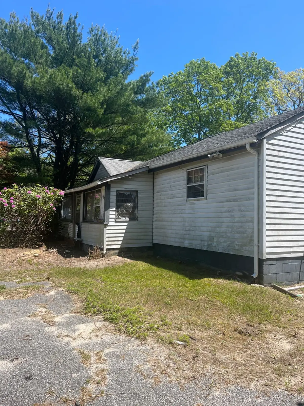Trying to stop a foreclosure in Medford: side of a white ranch beside a gravel driveway