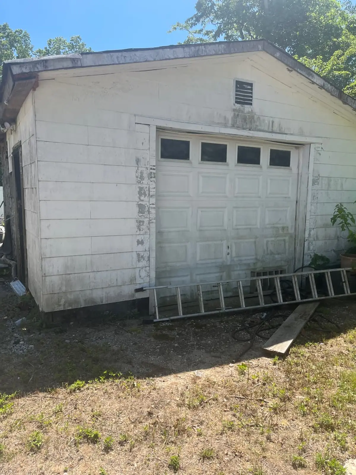Wondering which Medford neighborhoods we buy in: weathered detached garage with a ladder against it